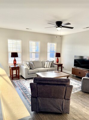 Relax in this stylish living room with a large sofa, armchair, and coffee table.