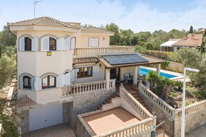 A Mediterranean-style villa with a swimming pool, stone walls, and a tiled roof. - YourIsland Villa Son Serra (Son Serra de Marina)
