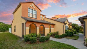 A two-story house with a large arched entrance, a prominent window, and a well-maintained lawn. - 3-Bed with pool - Close to beach (Melbourne)