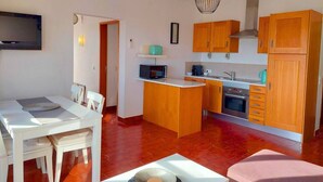 A compact kitchen with wooden cabinets, a microwave, and a stove. - ALVOR - ALVOR HOLIDAYS II (Portimão)