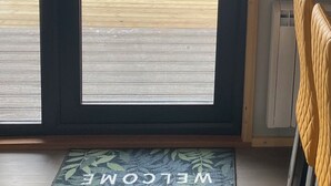 A door leading to a deck with a view of the ocean and hills. - Starview by Mirriemora l Shetland l St Ninians Isle l Cosy Pod (Bigton)