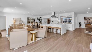 A spacious living area with a sofa set, a coffee table, and a dining bar with stools.