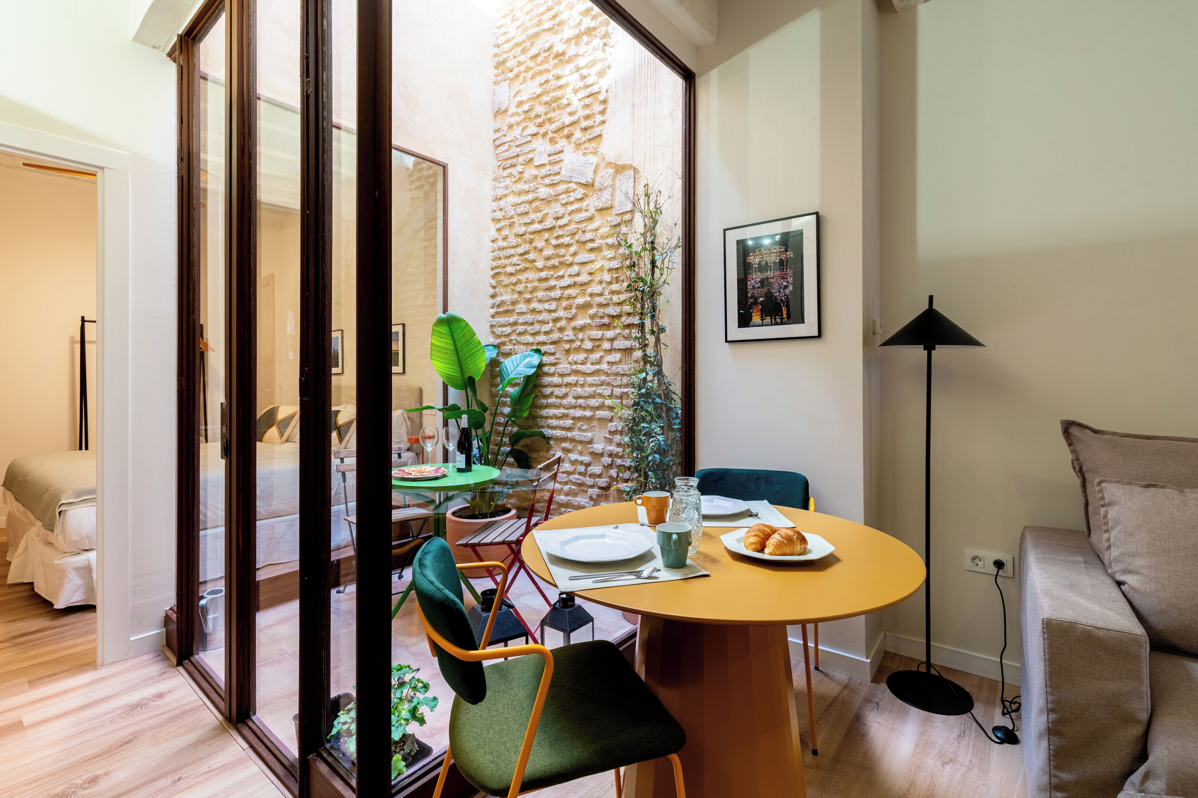 Un comedor con una mesa redonda, sillas y una planta.