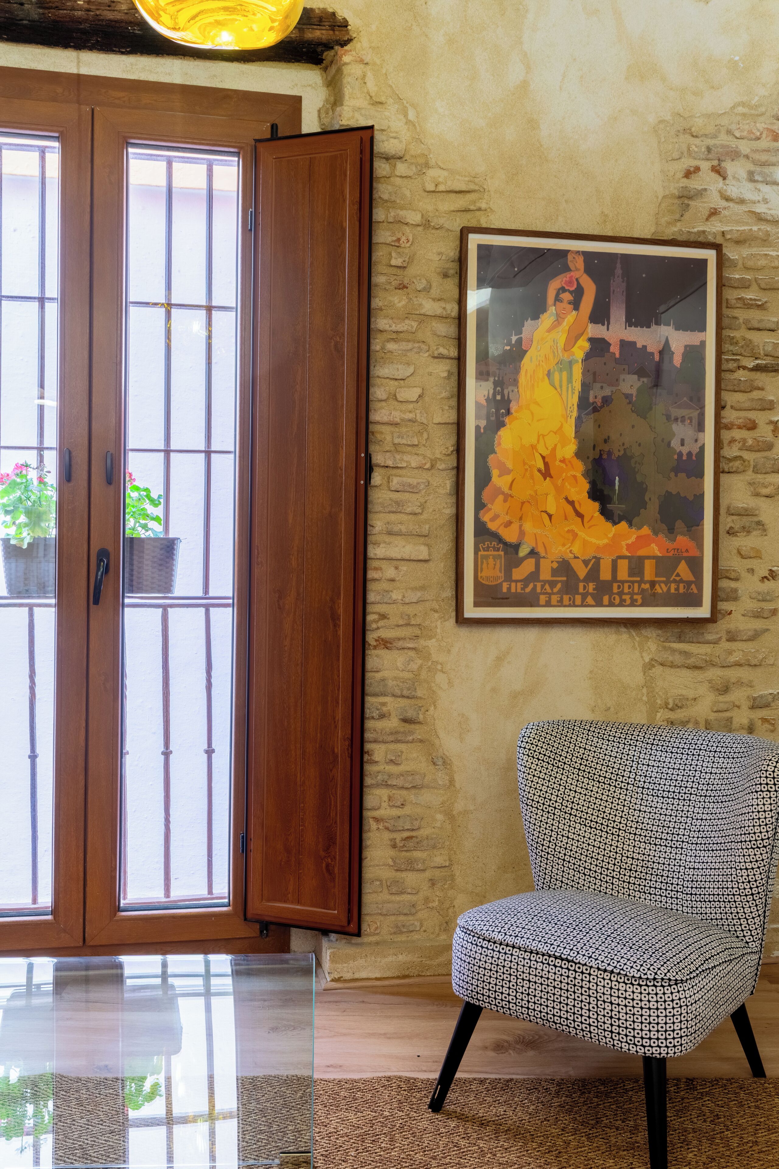 Une pièce avec une porte en bois, une affiche encadrée et une chaise à motifs.