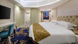 A hotel room with a bed, a desk, a chair, and a television. - Longtai Jindu Hotel (Huizhou Ganghui Shopping Center) (Huizhou)
