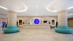 A spacious lobby with a reception desk, two large columns, and a central circular light fixture. - Longtai Jindu Hotel (Huizhou Ganghui Shopping Center) (Huizhou)