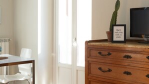 A room with a wooden dresser, a cactus plant, a framed quote, and a television. - Cadenabbia Lake Side Apartment 3 (Cadenabbia)