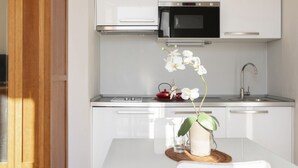 A modern kitchen with white cabinets, a stainless steel microwave, and a sink. - Cadenabbia Lake Side Apartment 3 (Cadenabbia)