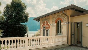 A building with a balcony, a mountain in the background, and a clear sky.