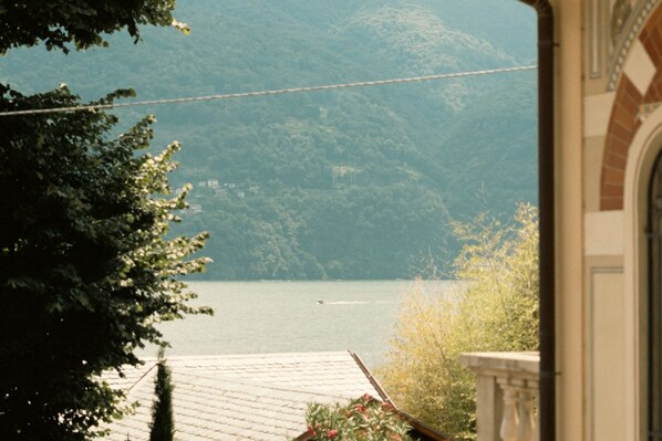 A view of a lake from a building with a tiled roof and a balcony.