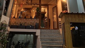 A two-story building with a sign for "Copper Lagan Biriyani" and "C2 Pods" indicating a restaurant and a pod hotel. - C2 PODS (Varanasi)