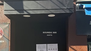 A black door with a sign reading "SOUNDS INN HOSTEL" and instructions for entering. - Sounds Inn (Seoul)