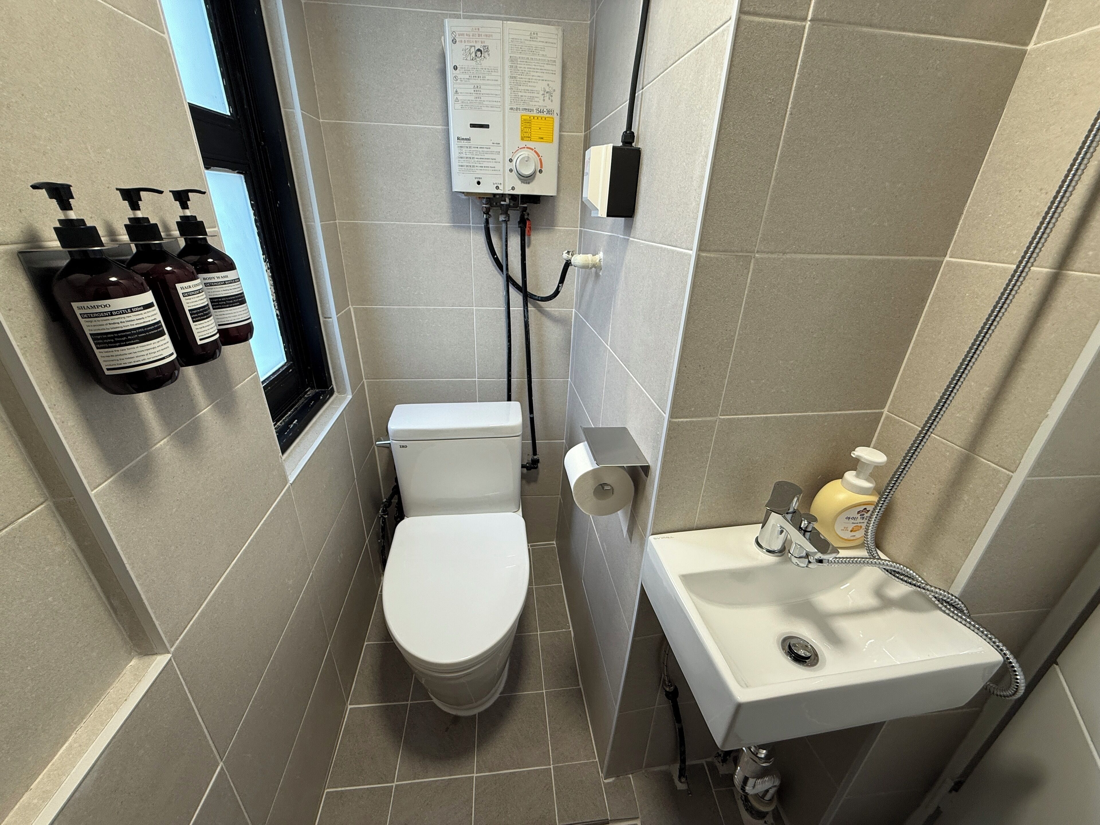 Eenvoudige eenpersoonskamer | Badkamer | Een douche, een haardroger, pantoffels, handdoeken