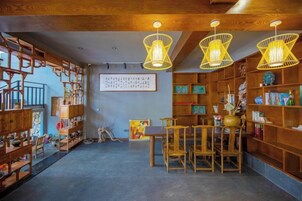 A traditional interior with wooden furniture, bookshelves, and hanging light fixtures.