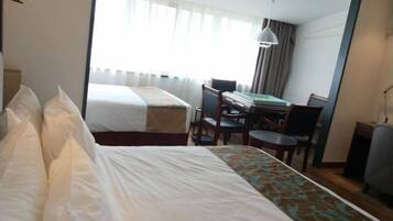 Ein Hotelzimmer mit zwei Betten, einem Schreibtisch und einem Stuhl.