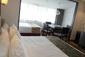 A hotel room with two beds, a desk, and a chair. - Baolong Yugang Hotel (Shanghai)