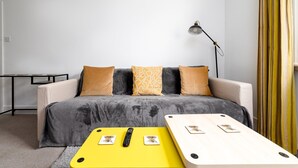 En moderne stue med en sofa, et gult sofabord og en lampe.