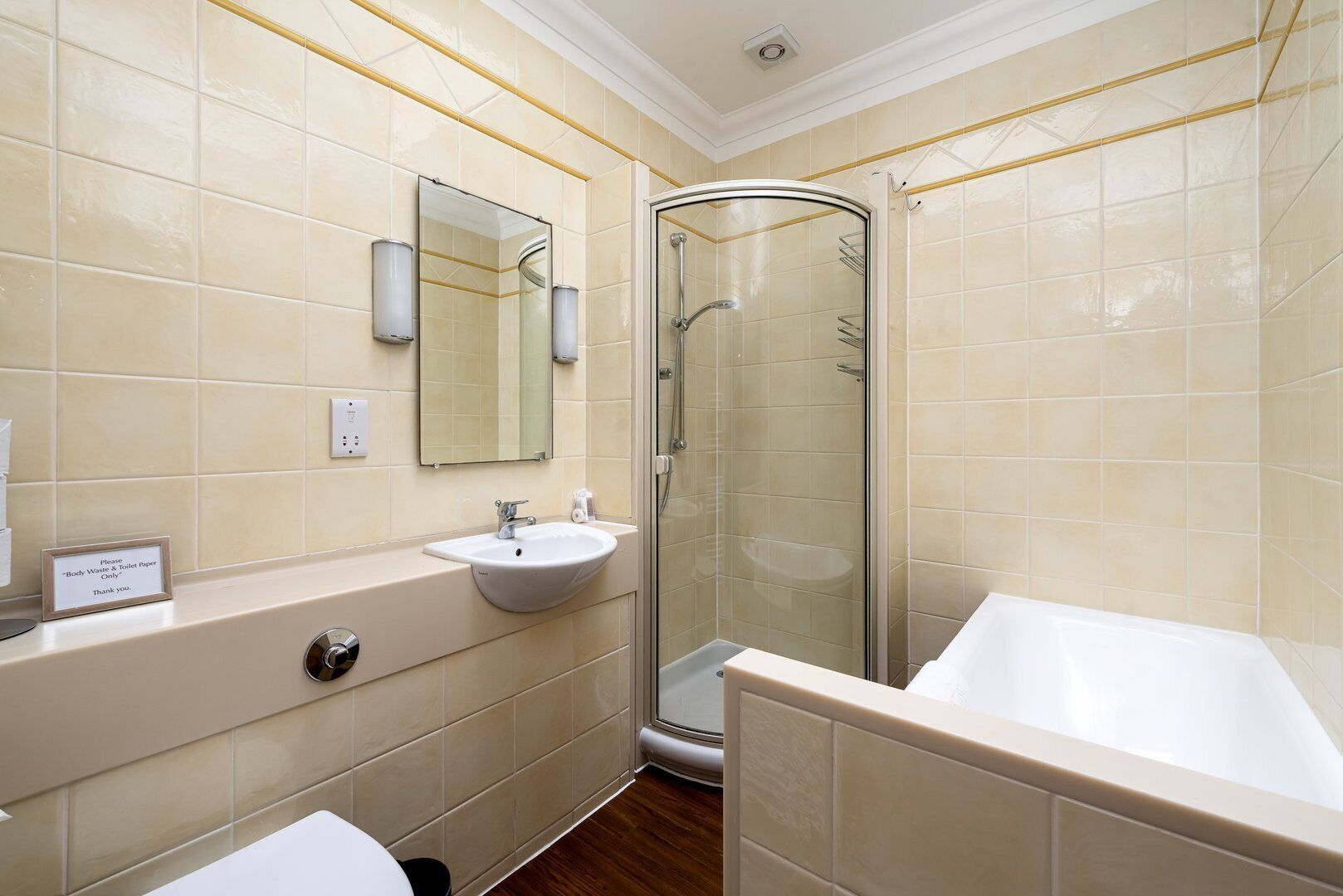 A modern bathroom with a curved shower, a sink, and a bathtub.
