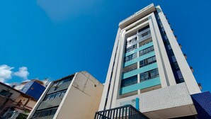 A tall, modern building with multiple balconies and a clear blue sky. - CORVE0104 - Marítima Residence (Salvador)