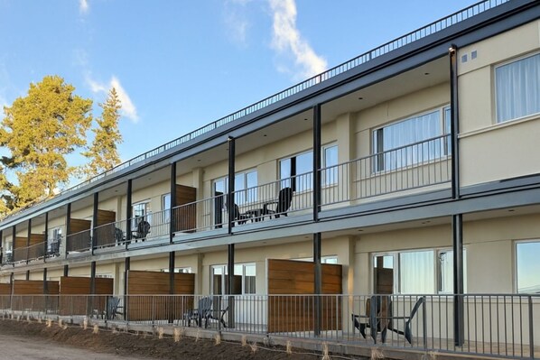 A multi-story residential building with balconies, large windows, and a clear sky. - Huinid Pioneros Aparts (San Carlos de Bariloche)