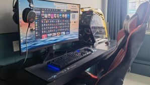 Een gaming setup bestaande uit een monitor, toetsenbord, koptelefoon en een gaming stoel.