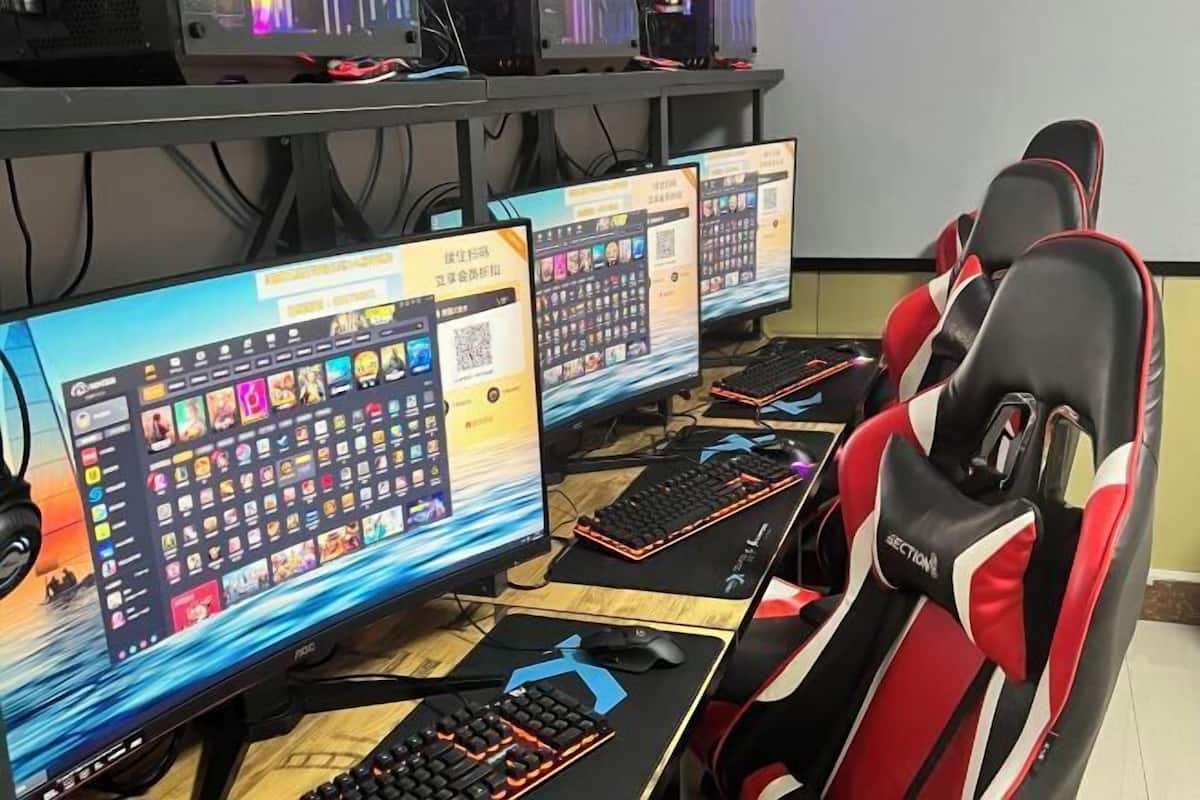 Postazione da gioco con schermi multipli, tastiere e una poltrona da corsa.