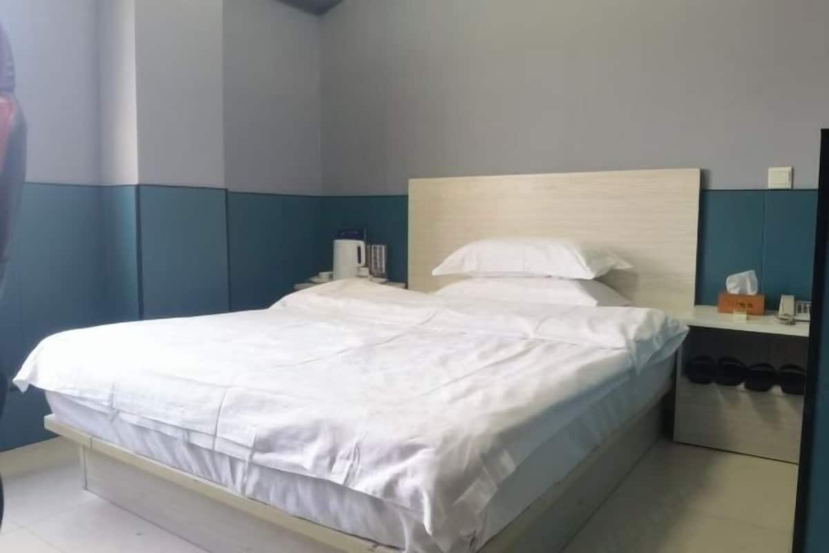 Un letto rifatto con lenzuola bianche in una camera d'albergo.