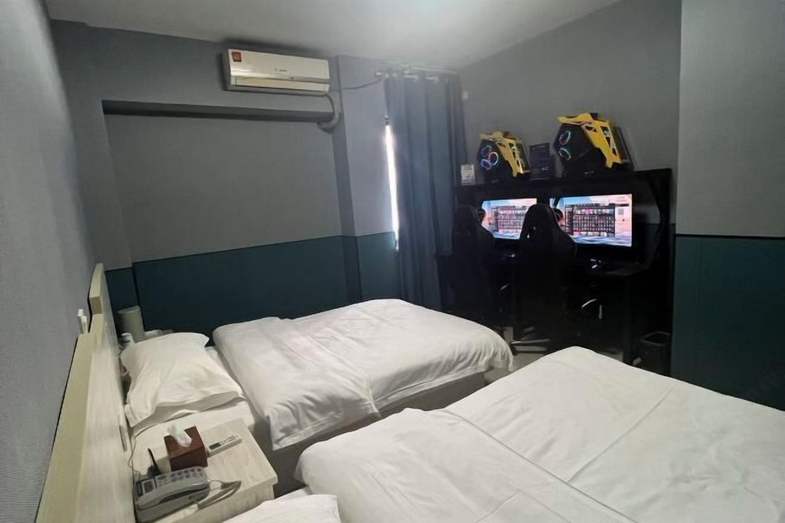 Une chambre d’hôtel avec deux lits, une télévision et un appareil de climatisation.