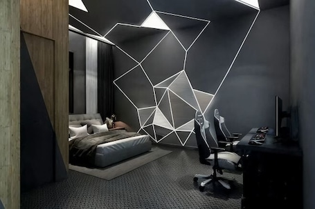 A modern bedroom with a geometric light installation, a bed, a desk, and a chair.. 211 E-sports Hotel (Shanghai Anting)