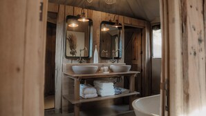 A wooden bathroom with two sinks, a large mirror, and a bathtub. - UNAI Atacama Luxury Tents (San Pedro de Atacama)