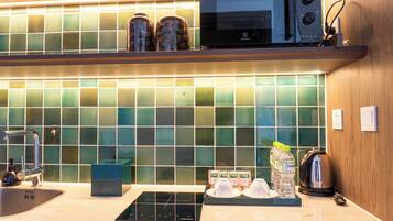 A modern kitchen with a microwave, kettle, and a water dispenser on the counter.