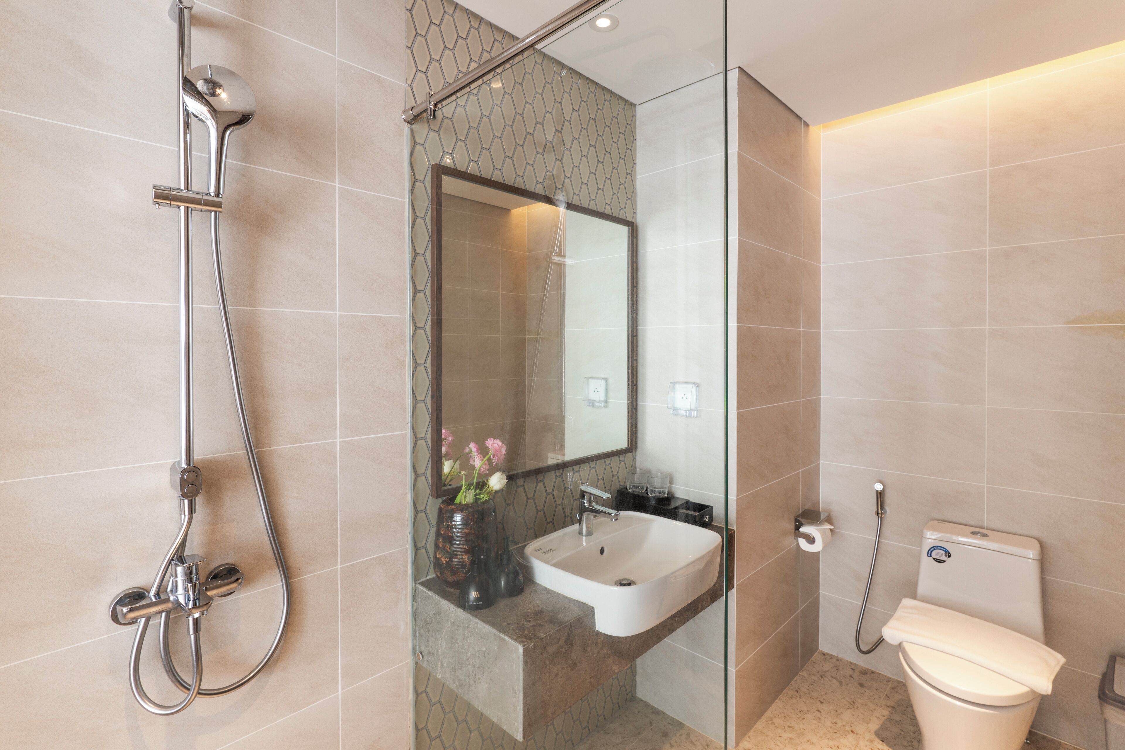 A modern bathroom with a glass-enclosed shower, a sink, and a toilet.