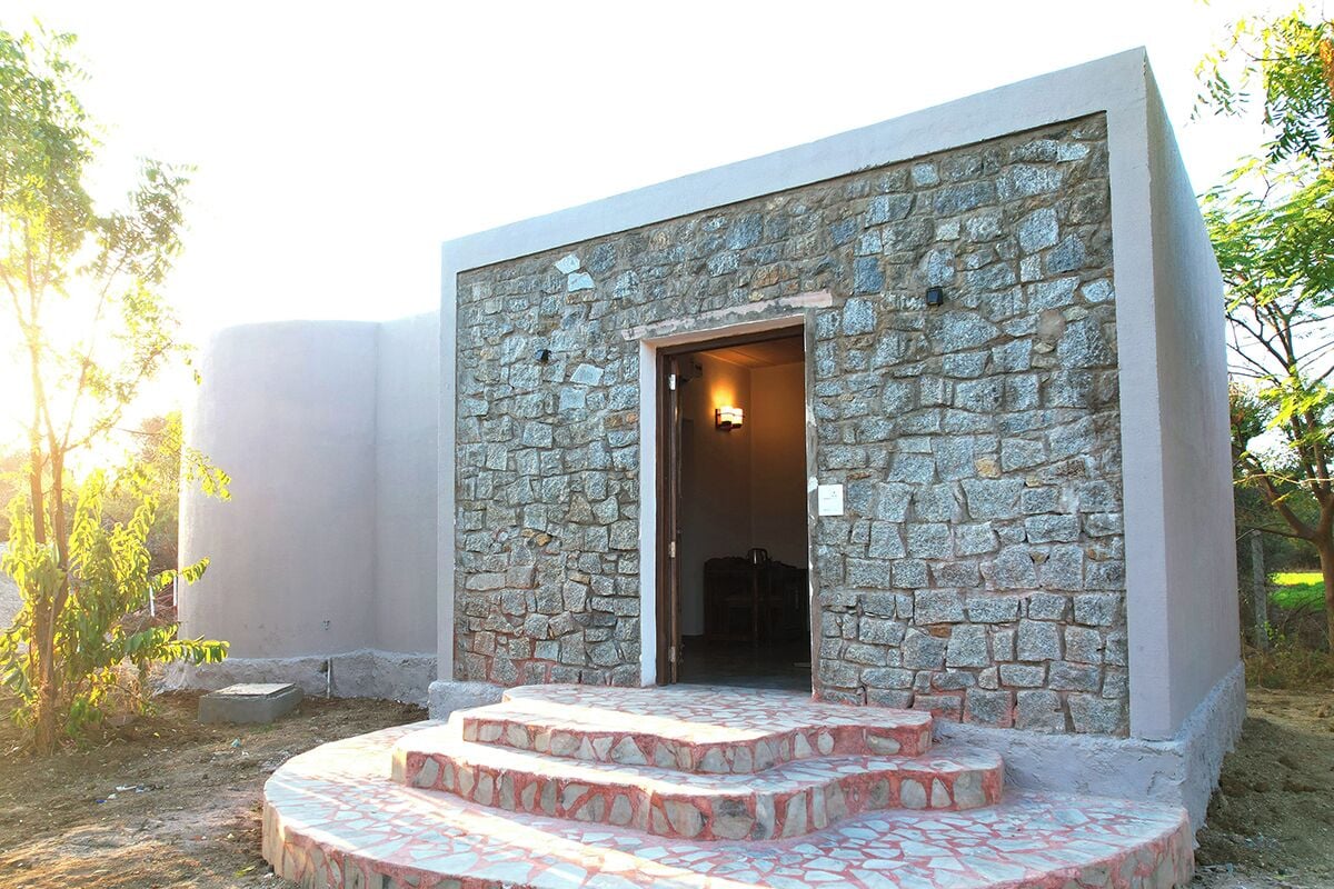 A modern building with a stone facade and a set of stairs leading to an entrance.