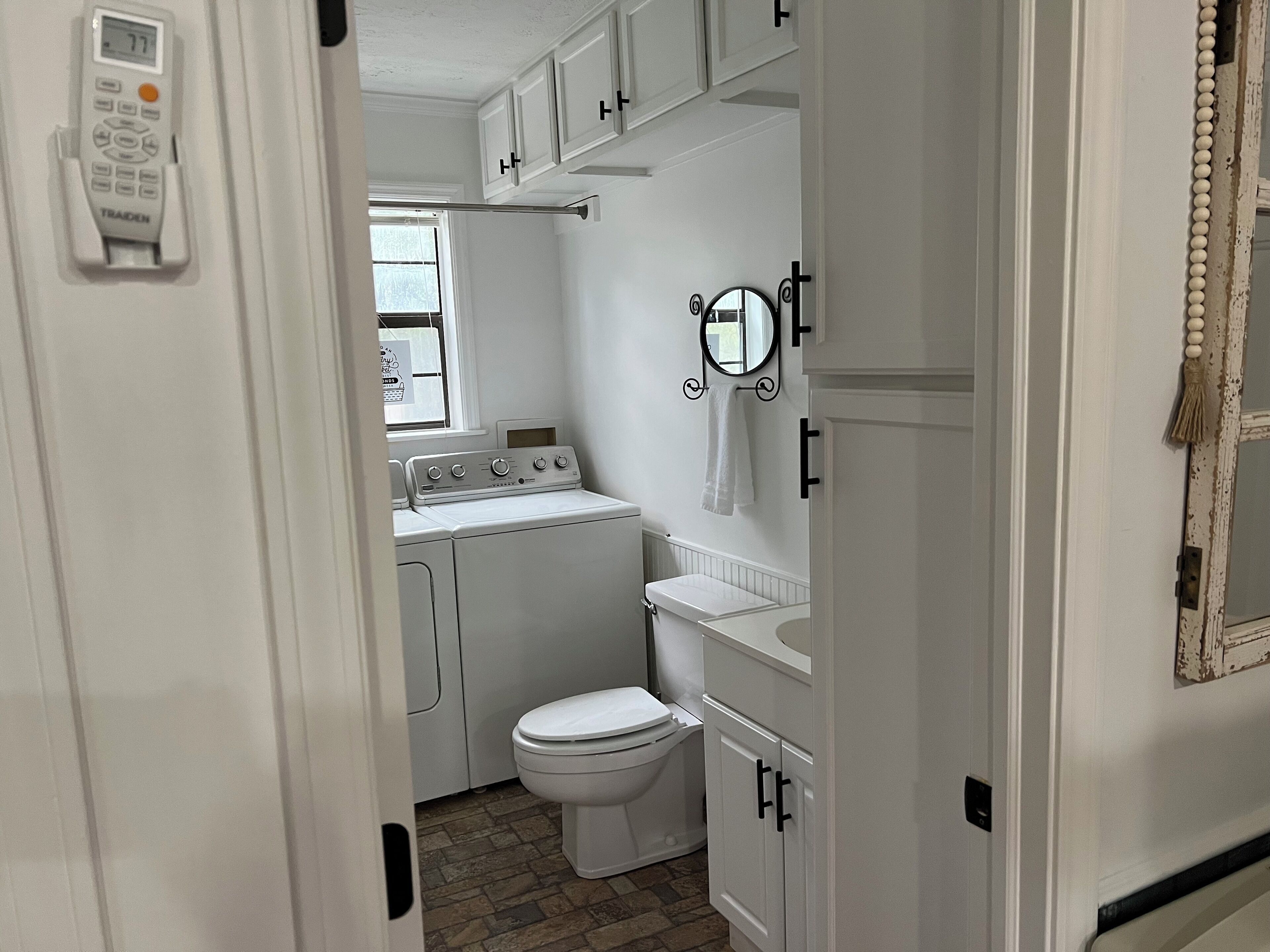 A compact laundry area with a washing machine, dryer, and a toilet.
