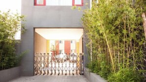 A gated entrance to a building with a concrete pathway leading to a door. - Vienna 3 Best Hotel (Beijing)