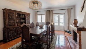 Comedor con mesa de madera, sillas y un aparador decorativo.