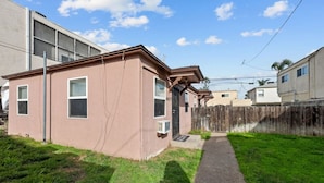 A single-story house with a front door, windows, and a small front yard with a pathway.
