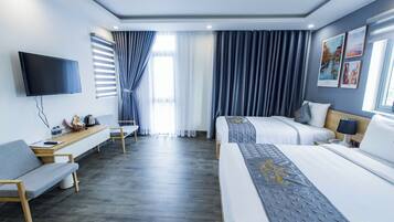 A hotel room with a bed, a desk, a TV, and a window with curtains.