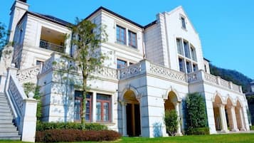 A large, white, two-story building with a symmetrical facade, multiple windows, and a central entrance.