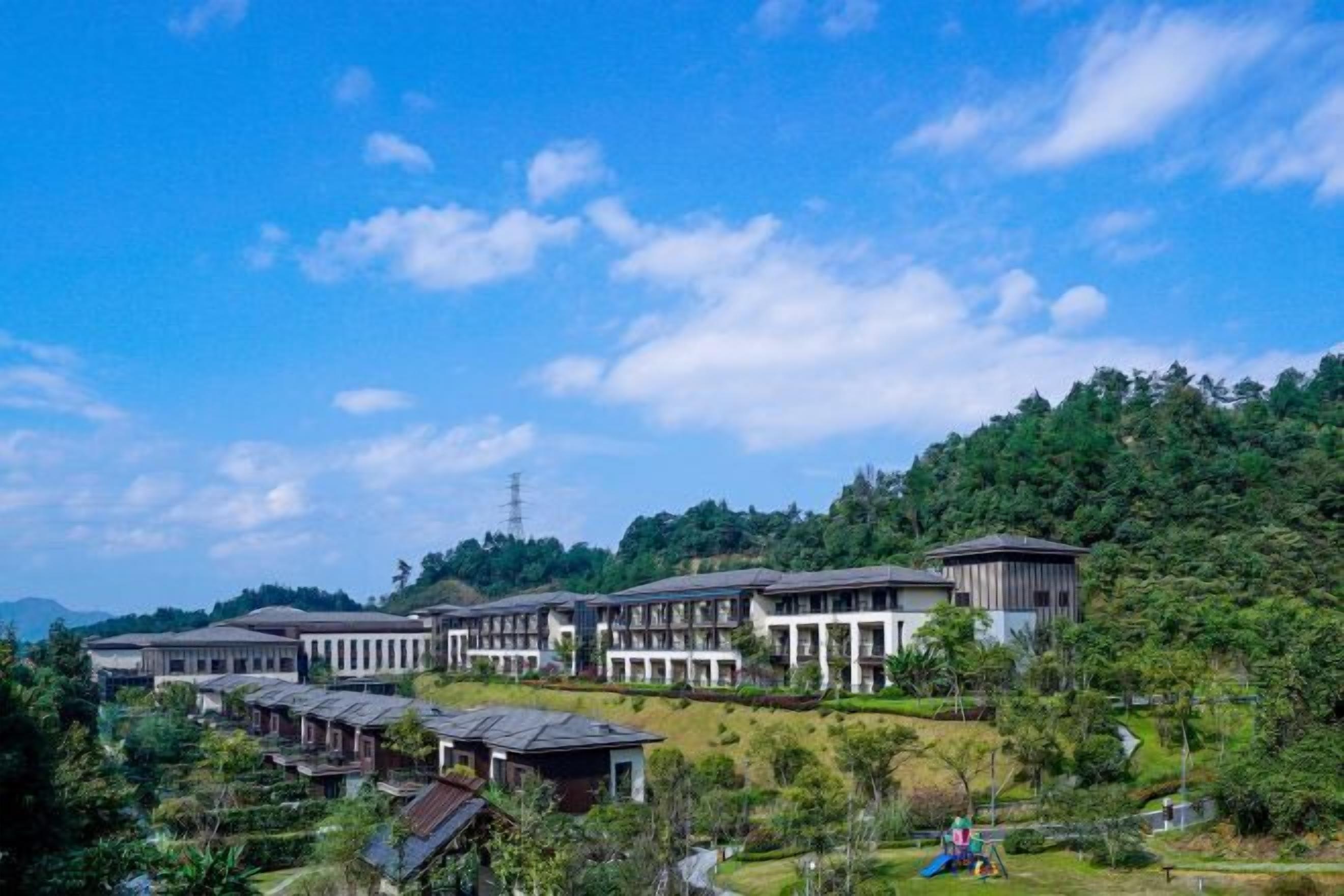 Un resort con varias edificaciones, exuberante vegetación y cielo despejado.