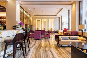 A hotel lobby with a reception desk, seating area, and a bar. - Nine Cloud Homestead Resort Hotel (Tonglu)