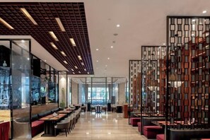 A modern restaurant with a long counter, seating area, and decorative partitions. - Nine Cloud Homestead Resort Hotel (Tonglu)