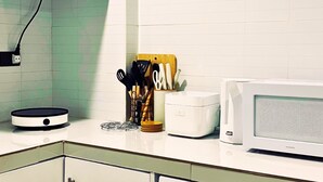 Une cuisine équipée d’une cuisinière à gaz, d’un four à micro-ondes et d’un bloc à couteaux.