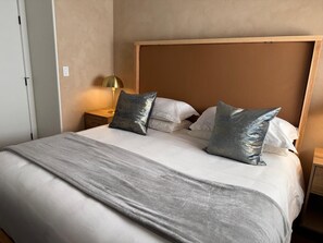 1 dormitorio, escritorio, tabla de planchar con plancha y ropa de cama