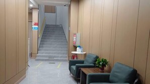 A hotel lobby with a staircase, green seating area, and a small table with a plant. - Lanzhou Sapphire Hotel (Lanzhou)