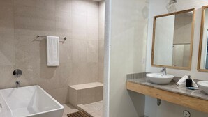 Une salle de bain moderne avec une baignoire sur pieds, un meuble-lavabo avec deux vasques et un grand miroir.
