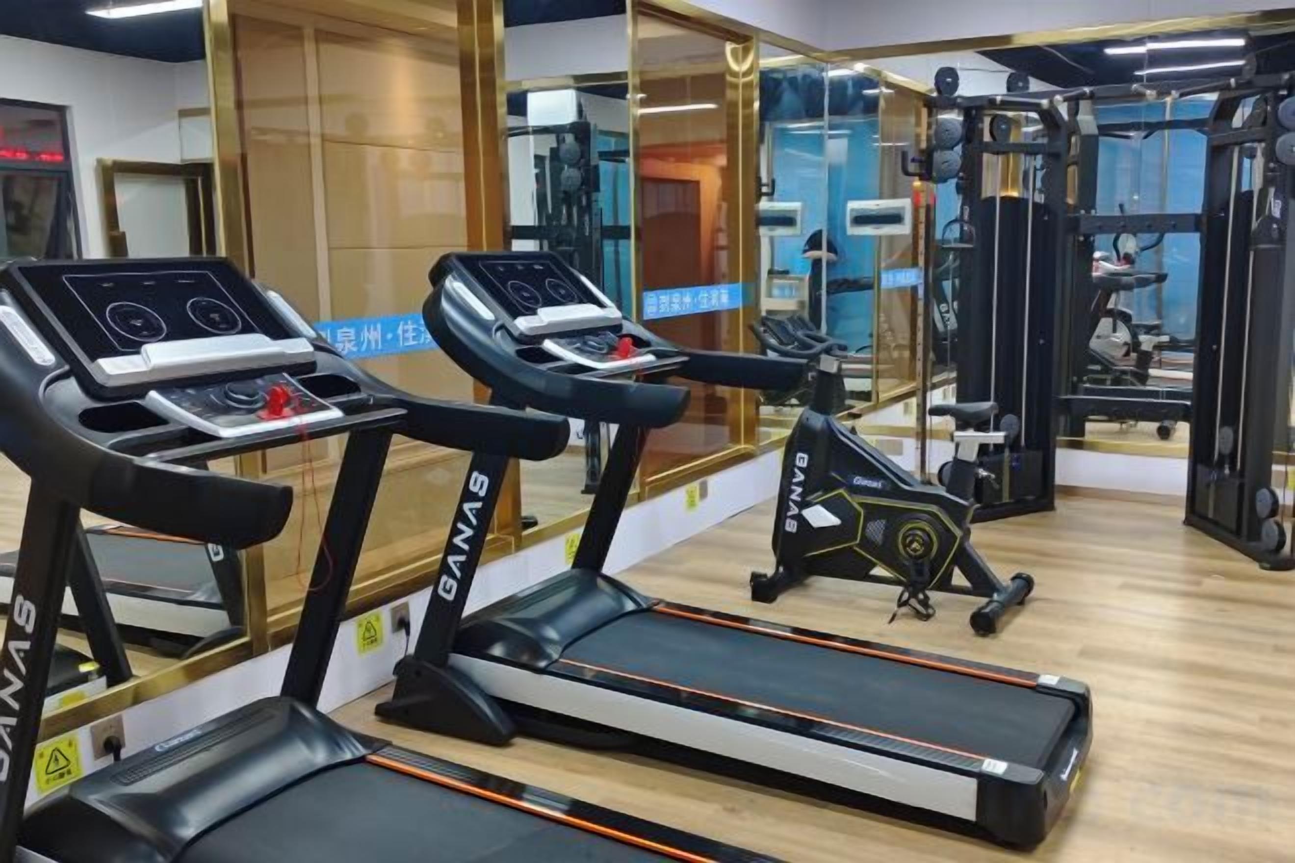 Ein Fitnessstudio mit Laufbändern, Ergometer und Krafttrainingsgeräten.