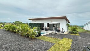 Une maison moderne dotée d’un patio, d’un espace salon extérieur et d’une piscine.