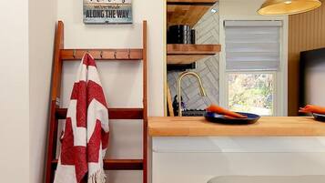 A kitchen with a wooden ladder, a red and white towel, and a wall-mounted sign.