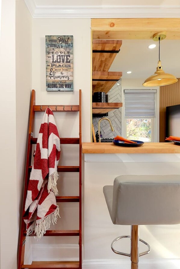 A kitchen with a wooden ladder, a red and white towel, and a wall-mounted sign. - Treehouse Suite | King BR | Spa bath | Calm Energy (Parkville)